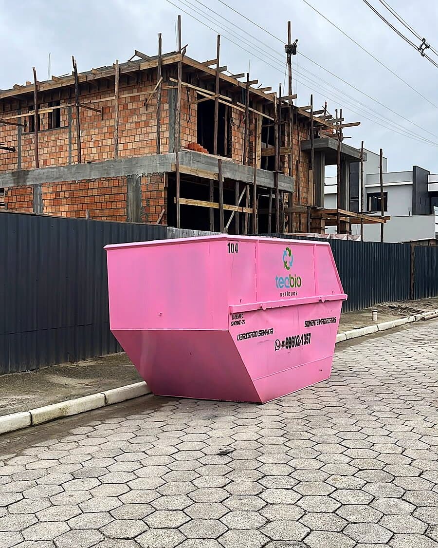 Caçamba rosa de 8m³ da Teqbio posicionada em frente a obra residencial