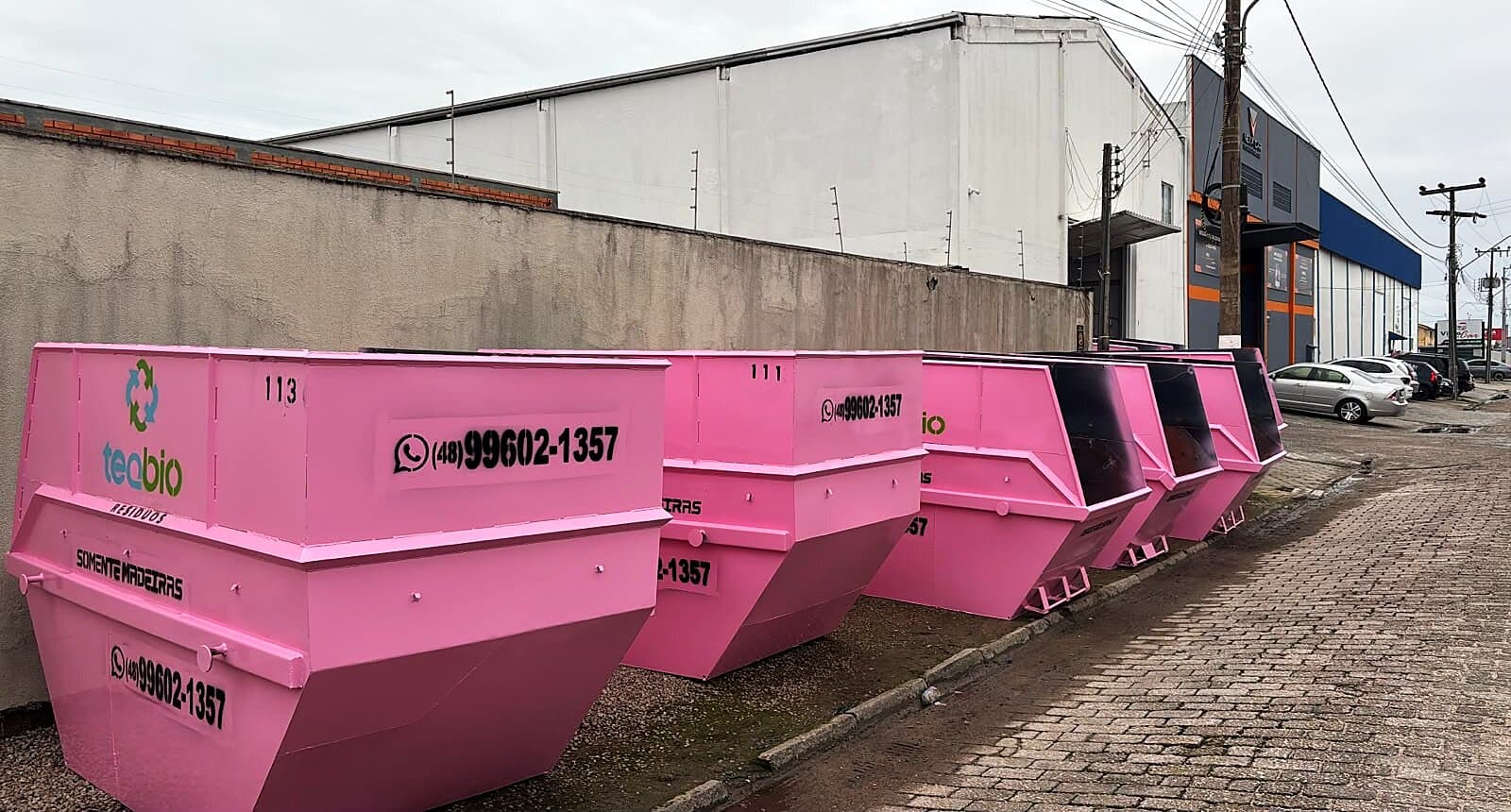 Fileira de caçambas rosas de 8m³ da Teqbio prontas para entrega
